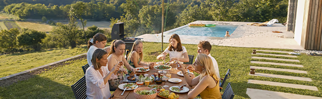 Family having dinner outside their luxury villa