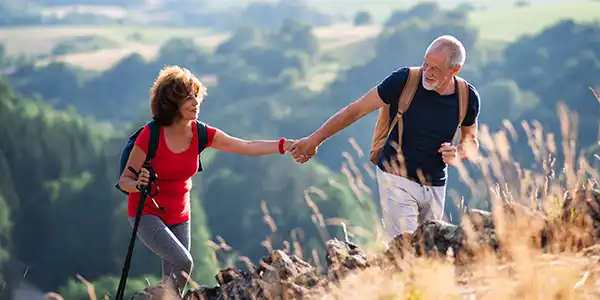 Older couple hiking up a mountain