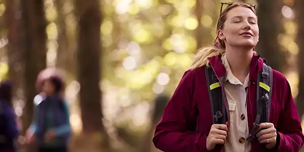 Woman on a hike with eyes closed
