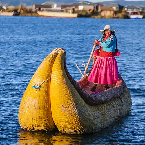 Peruvian woman sailing between Uros floating islands, Lake Tititcaca