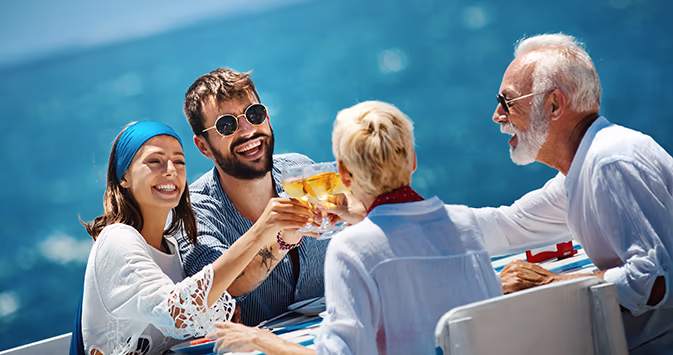 Two couples toast champagne on a boat
