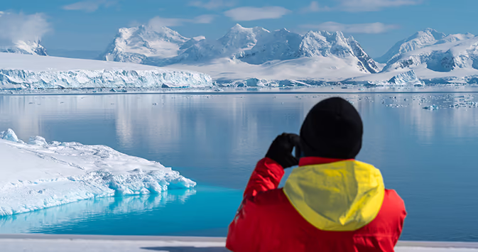 Man looks through binoculars in Antarctica