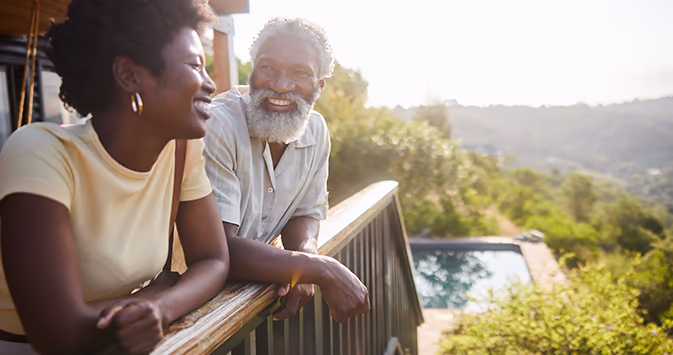 Older black couple on the porch of a villa