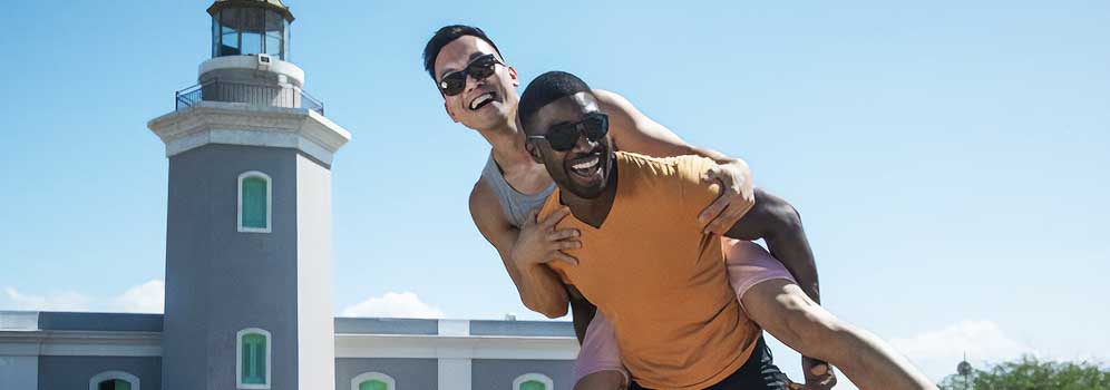 Gay couple goofing off by a Puerto Rico lighthouse