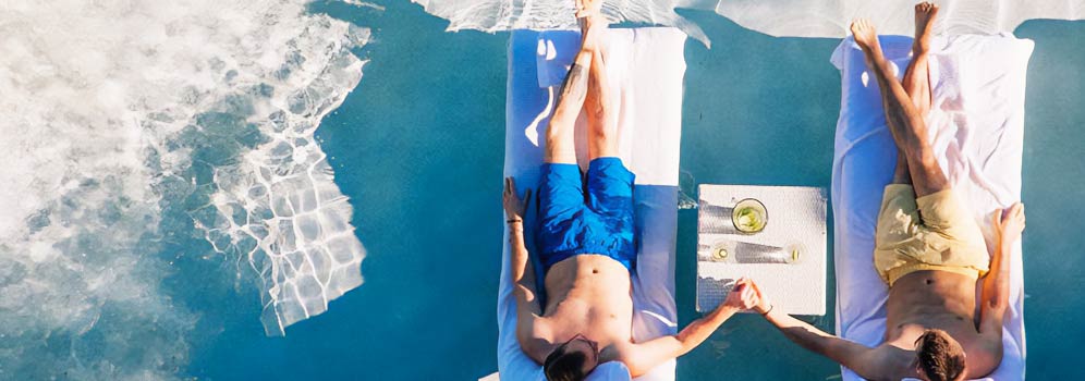 Two men holding hands in Puerto Rico poolchairs