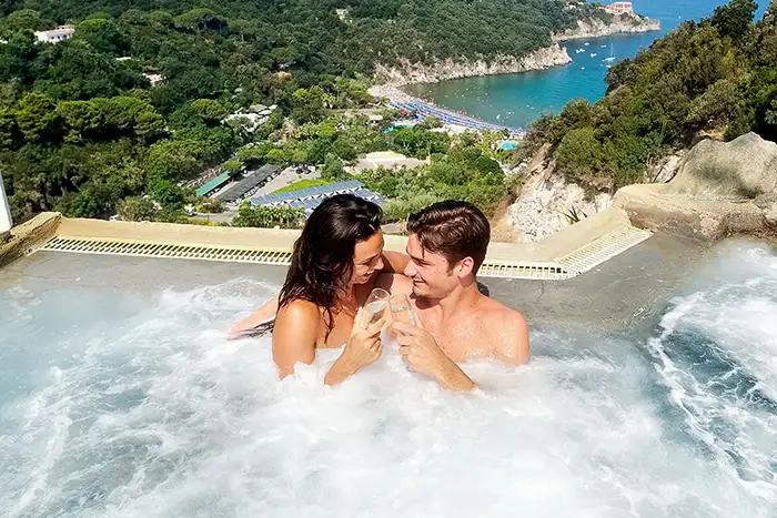 A couple toasts champagne in a pool on Ischia