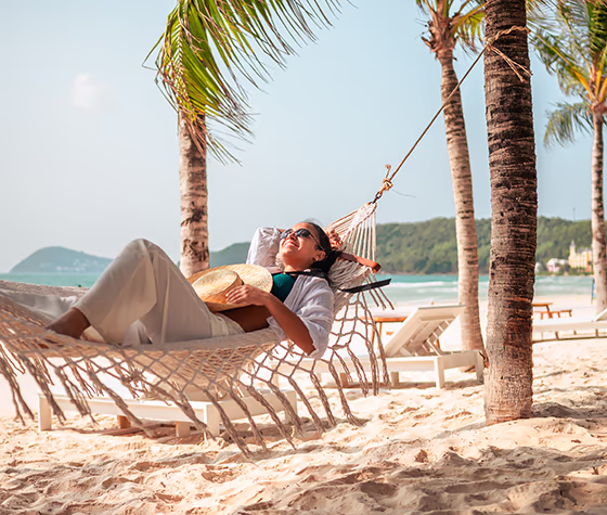 Woman relaxing in hammock on the beach