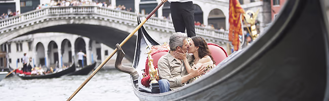 A mature couple kisses on a Venice Gondola