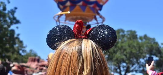 Woman with Minnie ears watching a parade at Disney World