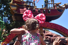 Little girl with Minnie ears watching a Disney parade