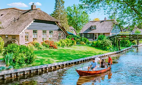 A family rides in a rowboat in a canal